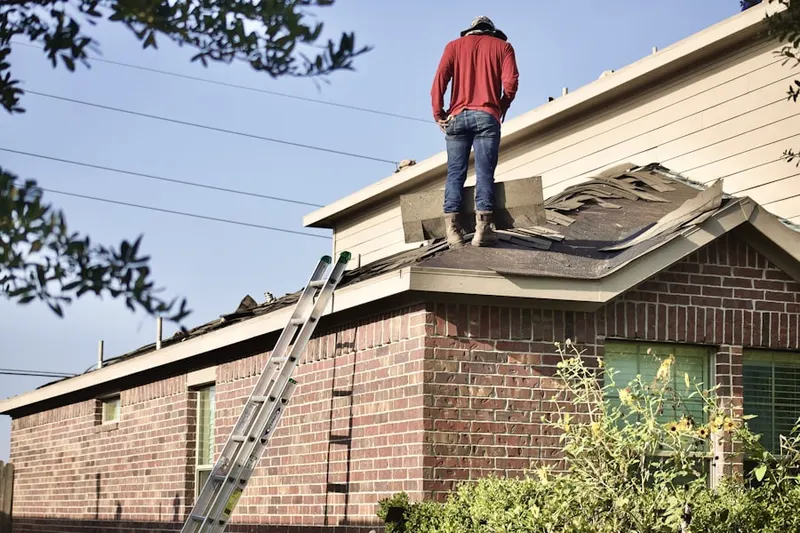 Professional roofer working on a residential roof in Springs